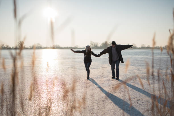 istock Couple stepping carefully on frozen lake 879768054