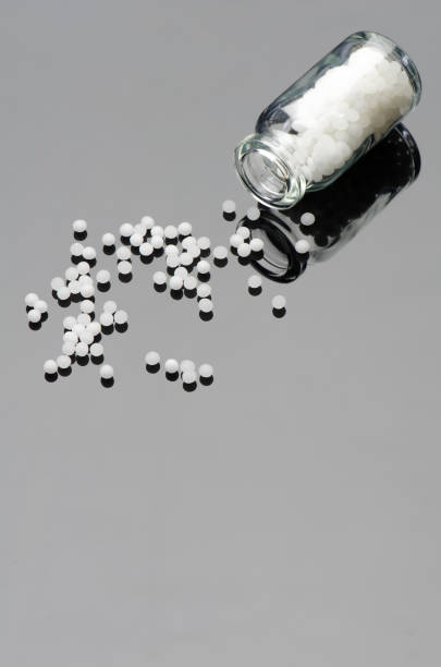 homeopathic globules with small bottle on a black acryl glass background