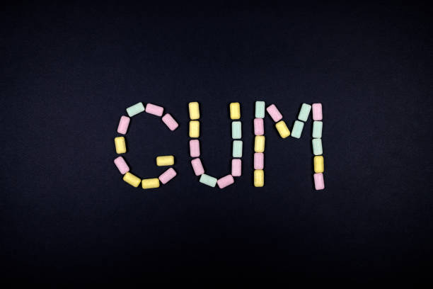 istock Word GUM written with chewing gum on black background 879770486