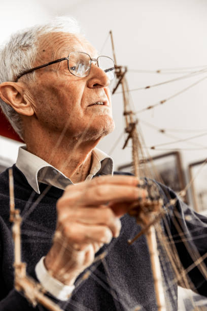 istock Portrait of Senior Man Constructing a Boat Model 879784846