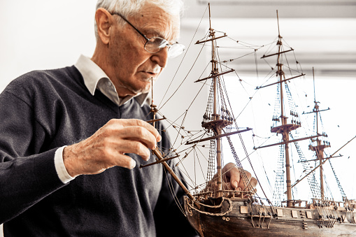Active Senior Man Constructing a Boat Model.