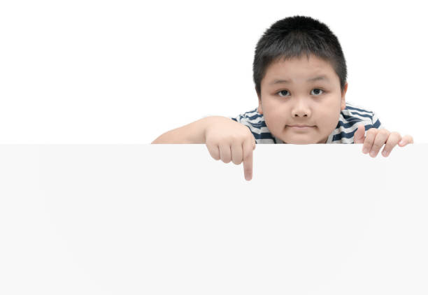 istock obese fat boy pointing on white banner - isolated on white background with copy space for input text 879785110