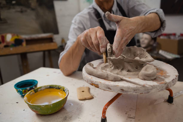 istock Mid-section of senior man molding clay 879796950