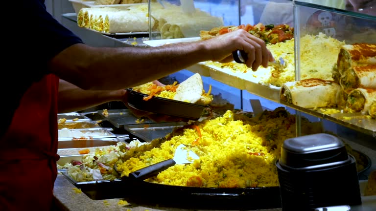 The seller pours Ready-to-eat food in La Boqueria market. Barcelona, Spain. Slow Motion