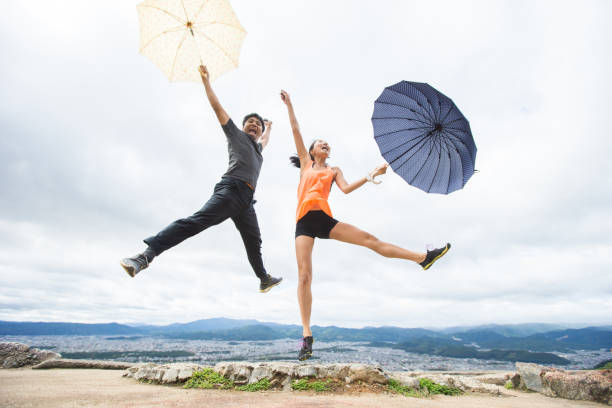 Businessman jumping for joy with umbrella