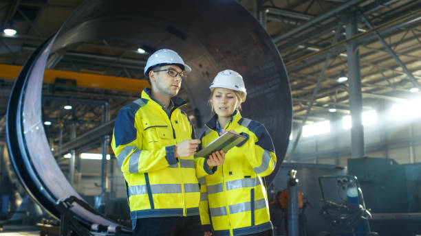 istock Male and Female Industrial Engineers Have Discussion while Using Tablet Computer. They Work in a Heavy Industry Manufacturing Factory. 879813668