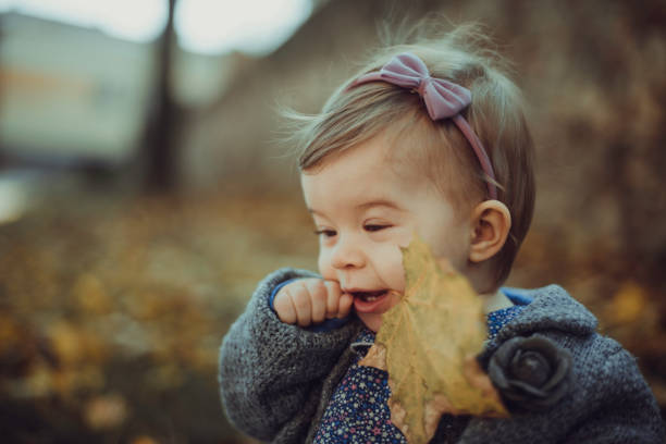 istock Baby girl and autumn leaf 879813806