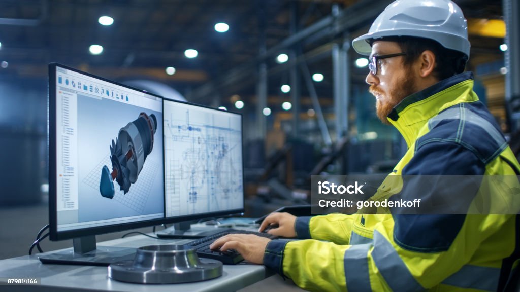 Inside the Heavy Industry Factory Industrial Engineer Works on the Personal Computer Designing Turbine/ Engine in 3D, Using CAD Program. Engineer Stock Photo