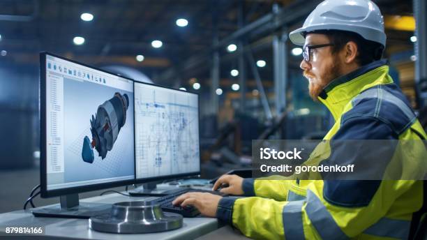 Inside The Heavy Industry Factory Industrial Engineer Works On The Personal Computer Designing Turbine Engine In 3d Using Cad Program Stock Photo - Download Image Now