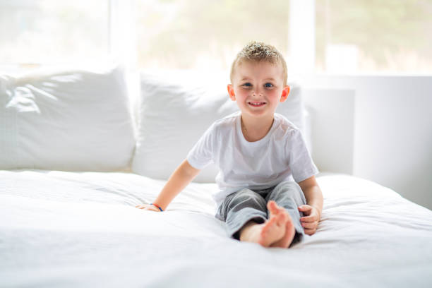 istock Young Boy sit on bed at home 879827784