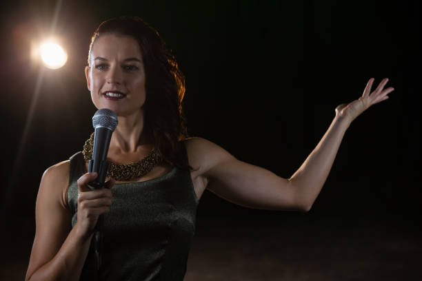 istock Female singer singing into a microphone 879828516