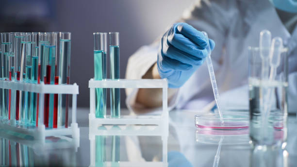 istock Chemist intern mixing liquids, waiting for chemical reaction at science lab 879831234