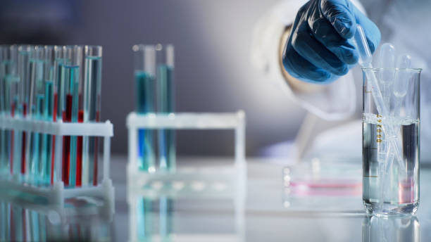 istock Laboratory assistant putting pipette into sterile mixture after conducting tests 879831266