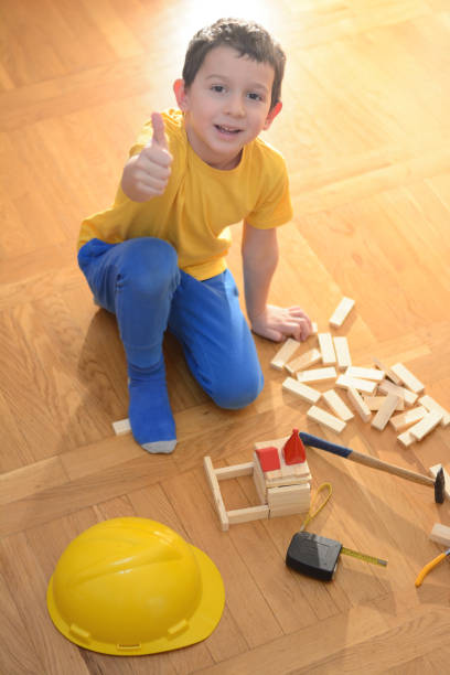 istock Beautiful boy is playing with toy blocks and hand tools 879831330