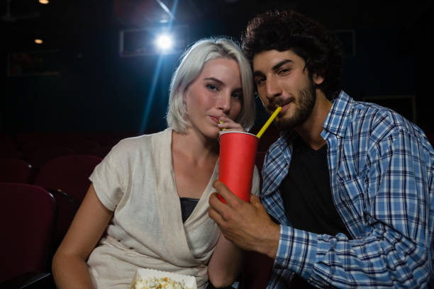 istock Couple having drinks while watching movie 879836818