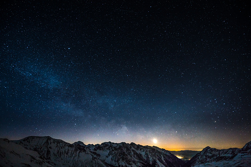 milky way night sky shot from obertauern austria snow covered mountain summits and rising moon