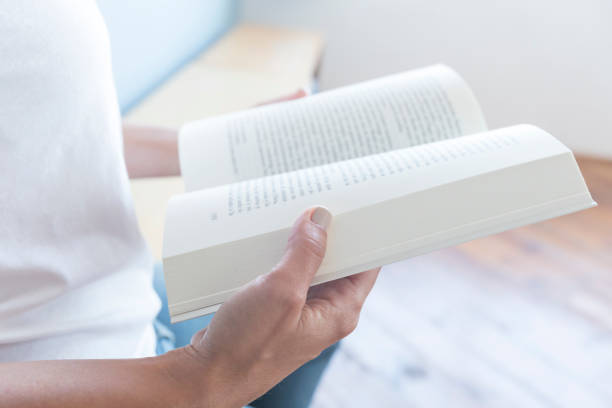 istock Closeup of a  reader reading a book at home 879840250