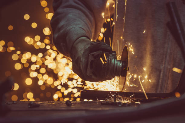 istock Creative and colored, horizontal image of man working with steel pipe, producing golden sparks on the work surface. 879844558