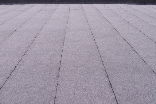 Flat surfaced roof coating. Heating and melting bitumen roofing felt background pattern