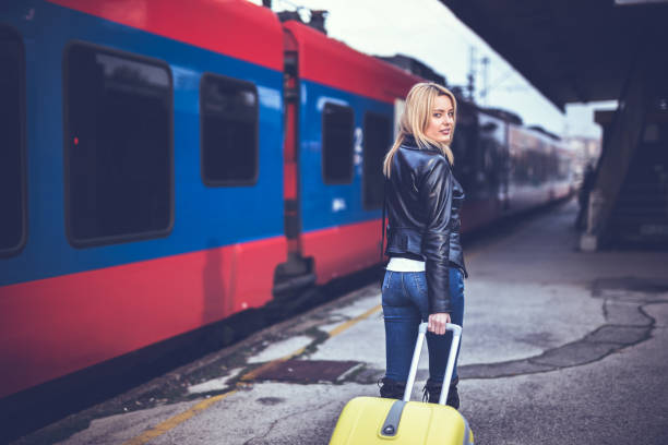 istock Handsome lady on train station with suitcase 879845640