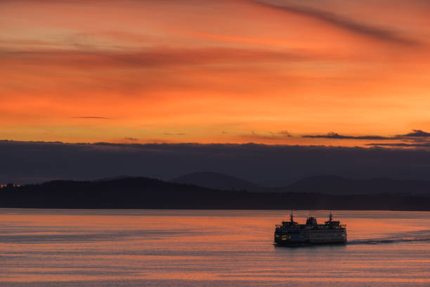 Seattles colors A ferry passing on Elliott Bay with a sunset. bainbridge island photos stock pictures, royalty-free photos & images