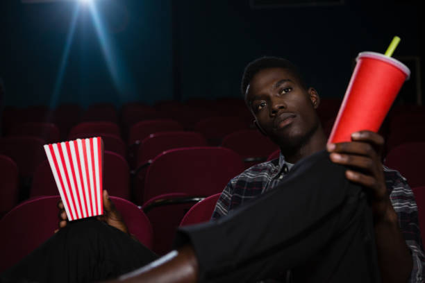 istock Man having popcorn and cold drink while watching movie 879849128