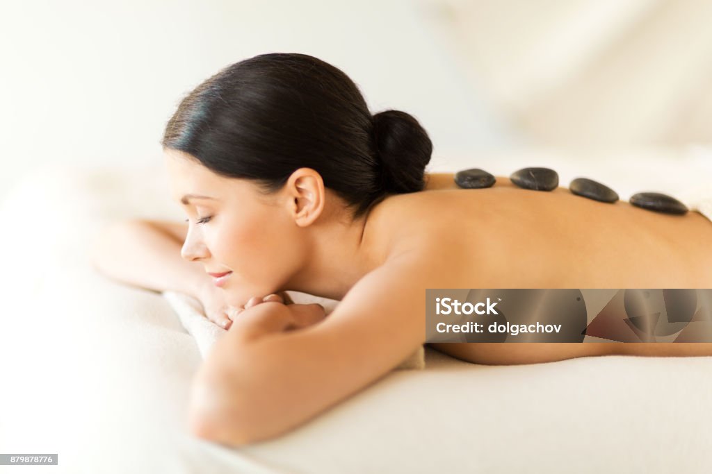 woman in spa with hot stones picture of woman in spa salon with hot stones Lastone Therapy Stock Photo