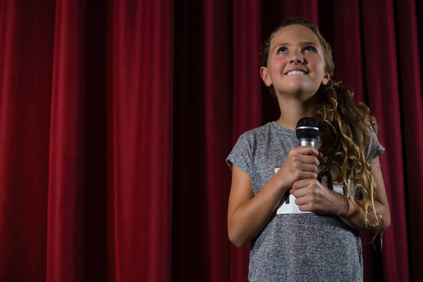istock Girl holding microphone on stage 879879066