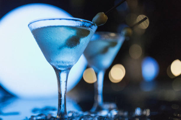 toma de noche al aire libre de dos martinis con aceitunas, como tiro en nassau. - martini martini glass dirty martini olive fotografías e imágenes de stock