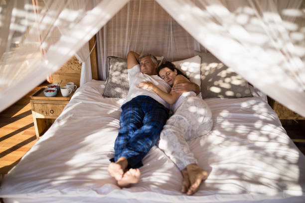 istock Couple relaxing in canopy bed 879897040