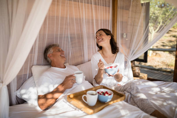 istock Happy couple having breakfast in canopy bed 879897124