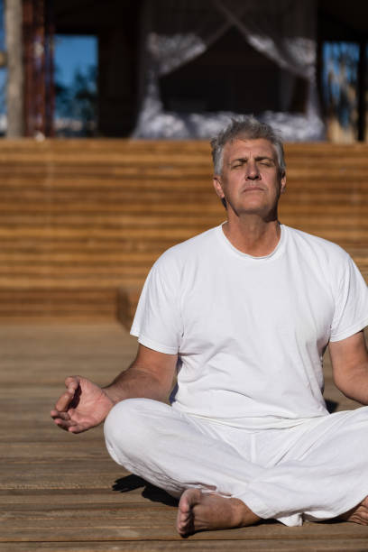 istock Man practicing yoga on wooden plank 879897748