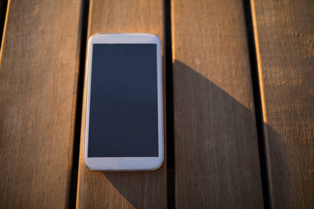 Close-up of mobile phone on wooden plank