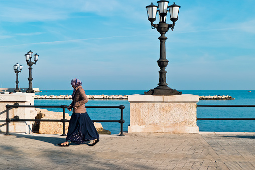 Bari,Italy-24/november/2017; african woman an autumn morning on the seafront of Bari city goes fast and safe.