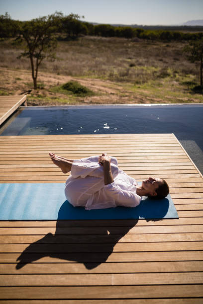 istock Woman practicing yoga on at poolside 879909608