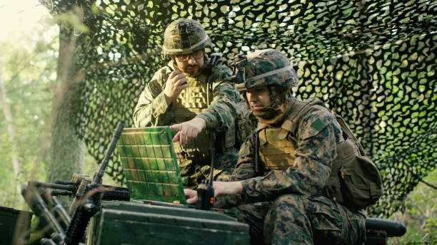 wojskowa baza inscenizacyjne, główny inżynier używa radia i armii klasy laptopa. operacja leśna / misja w toku. - sports uniform audio zdjęcia i obrazy z banku zdjęć