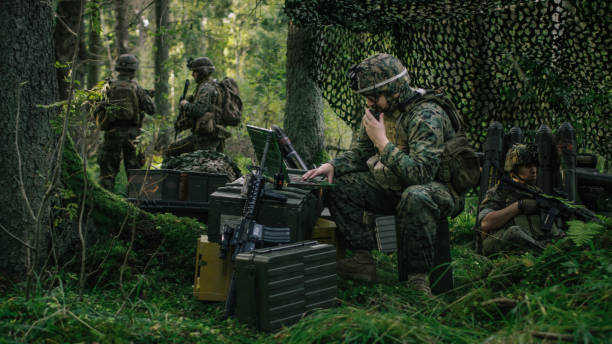 Military Staging Area, Chief Engineer Uses Radio and Army Grade Laptop. Forest Operation/ Mission in Progress. Military Staging Area, Chief Engineer Uses Radio and Army Grade Laptop. Forest Operation/ Mission in Progress. transceiver stock pictures, royalty-free photos & images