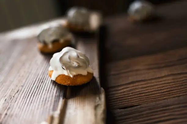 Cookies in white chocolate on a wooden table and a dark background. Copy space. Side view