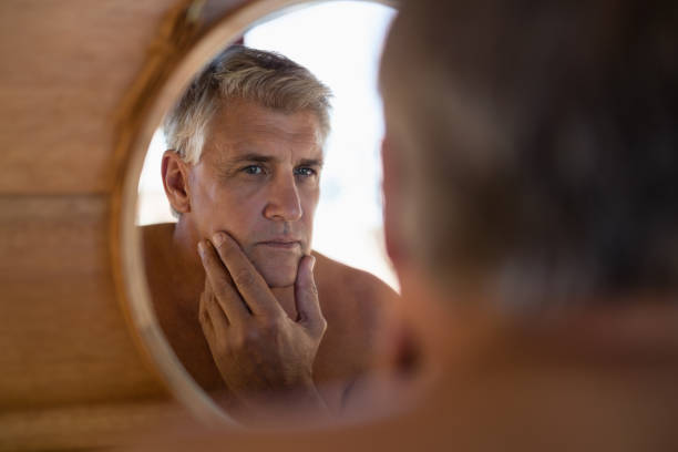 istock Man looking at mirror in cottage 879913676