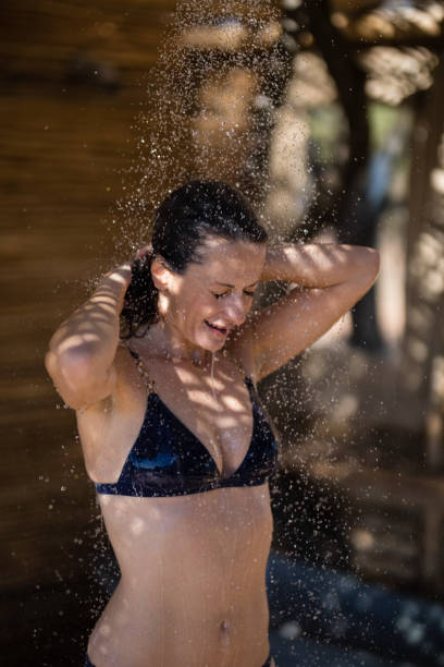 istock Smiling woman taking bath in shower 879918650