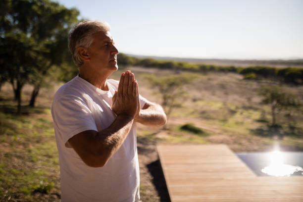 istock Man practising yoga on wooden plank 879922878