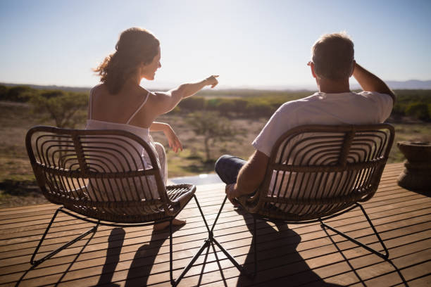 istock Senior couple sitting on chairs at the resort 879928520