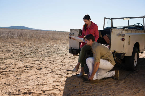 istock Woman with man holding map on landscape 879934872