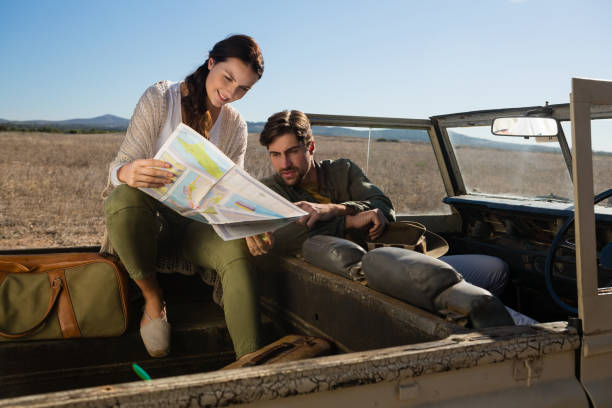istock Young couple reading map in off road vehicle 879934878