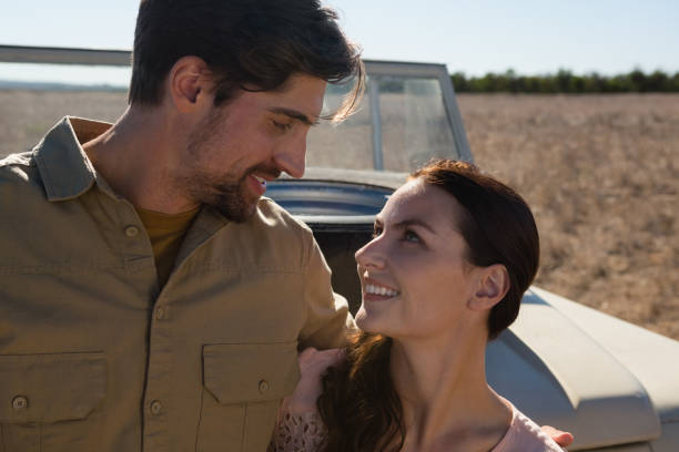 istock Couple by off road vehicle looking at each other 879935008