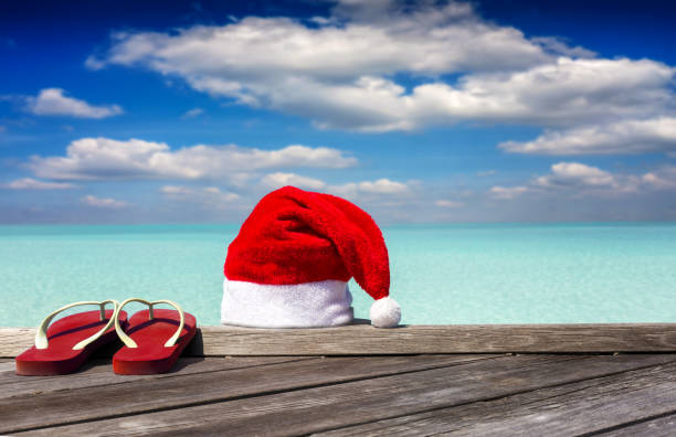 santa hat and red flip flops on a pier in the tropics - christmas beach sun tropical climate imagens e fotografias de stock