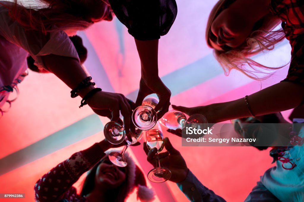 Young people with glasses of champagne at Christmas party Young people with glasses of champagne at Christmas party. Friends celebrate New Year at home Party - Social Event Stock Photo