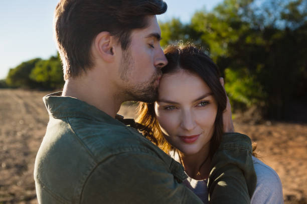 istock Man kissing woman on field 879942716