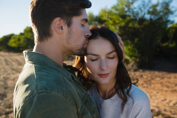 istock Man kissing woman on landscape 879942744