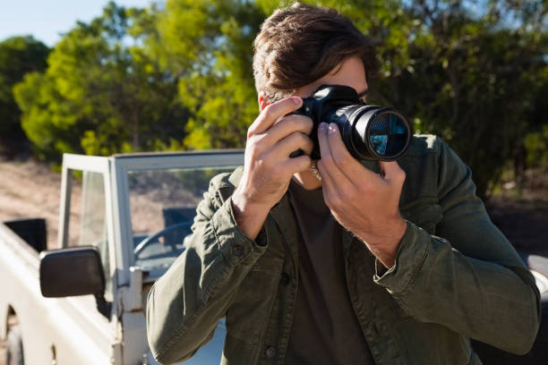 istock Man photographing from camera by vehicle 879947074